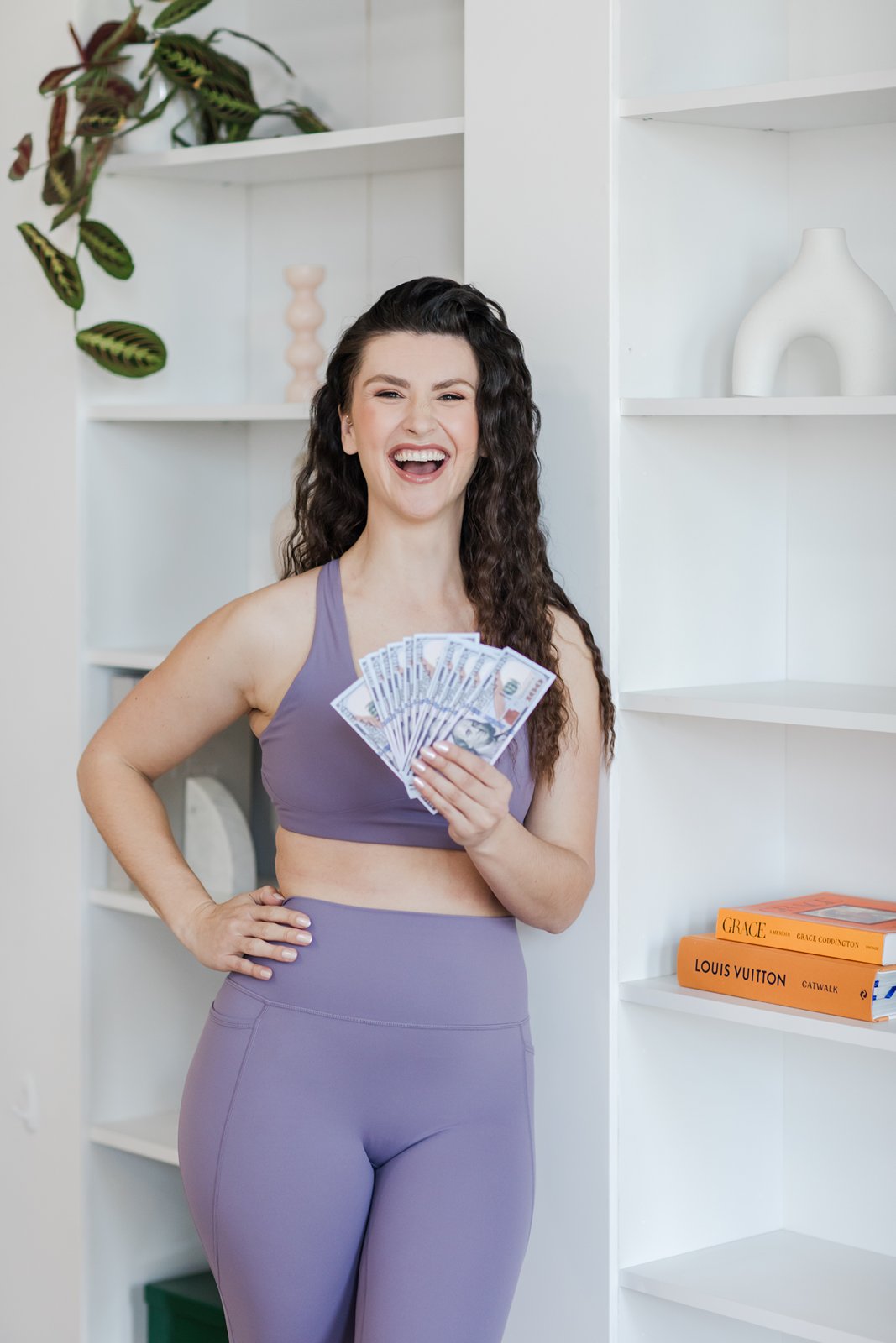 Hailey Ann Co Bookkeeper and Somatic Money Coach for Female founders holding a money fan